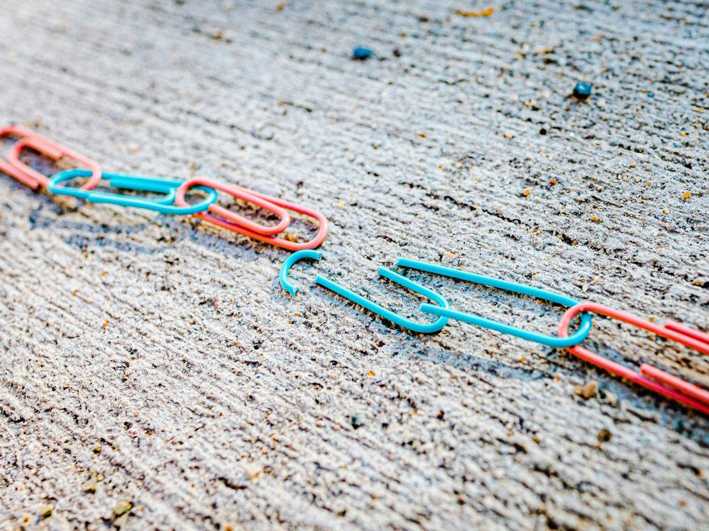 Broken paper clip in a chain of paper clips